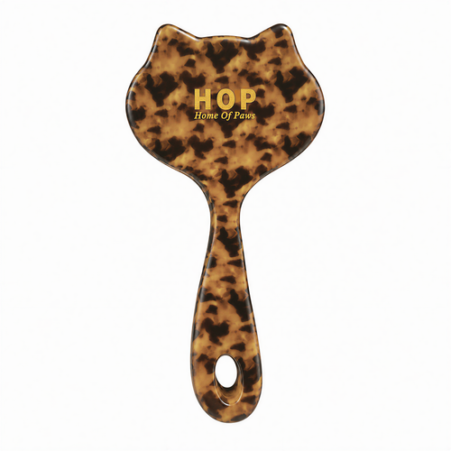 Back of a leopard-print cat-shaped HOP slicker brush with gold lettering and a hanging hole.