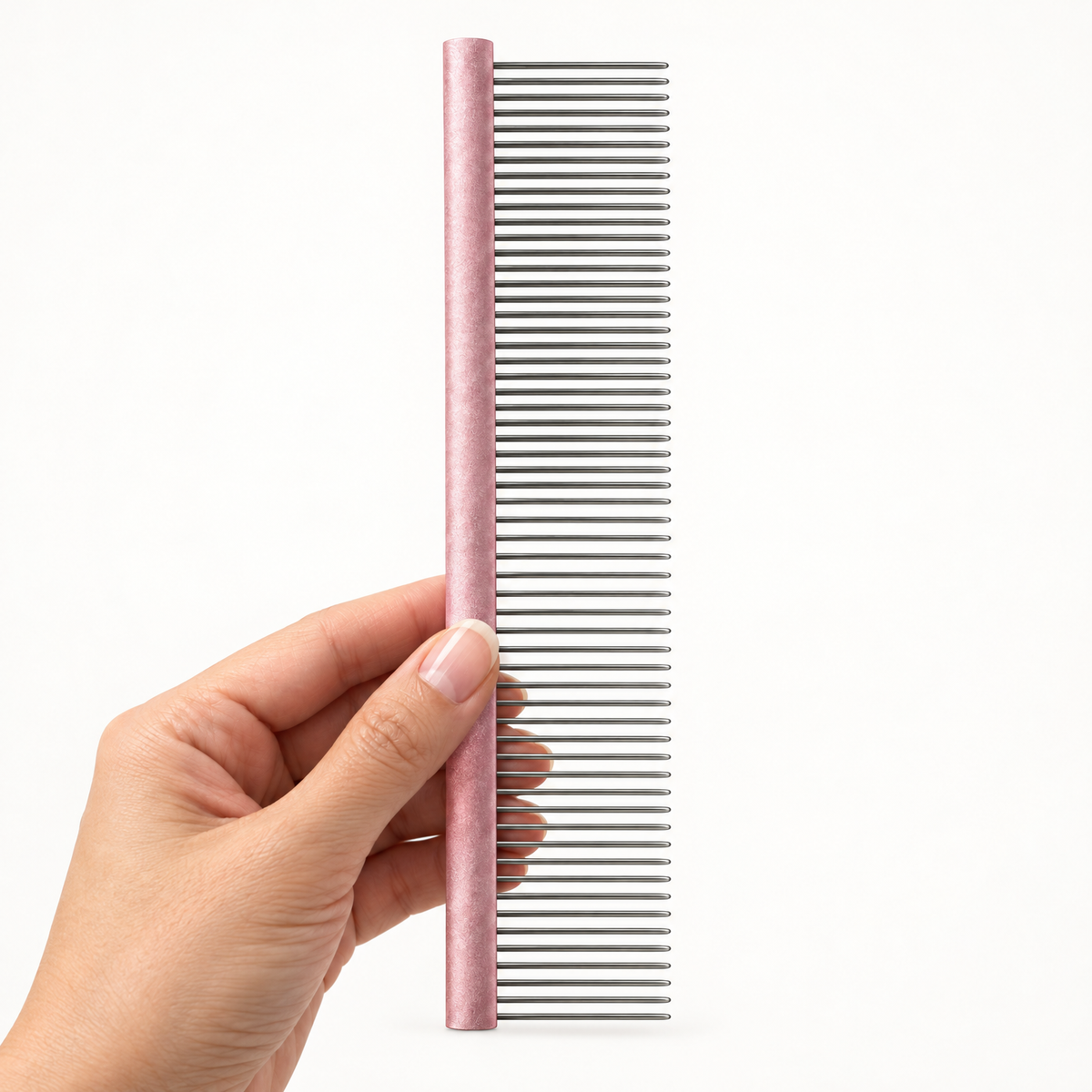 Hand holding the dual-density metal grooming comb upright
