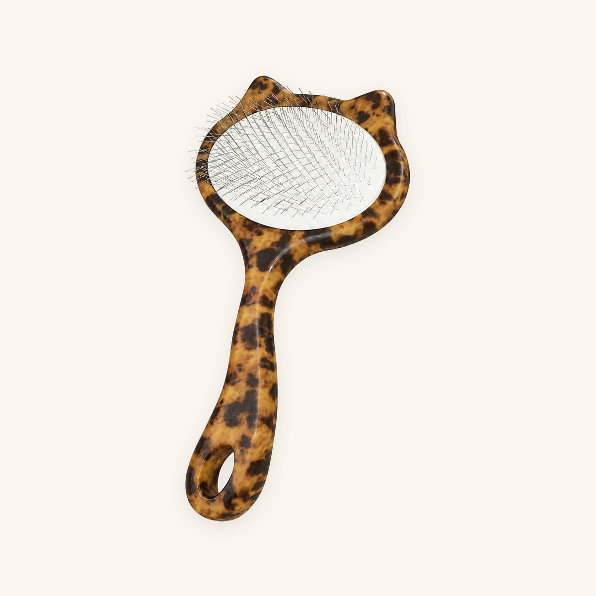 Leopard cat-shaped slicker brush with a white pin cushion on a cream background