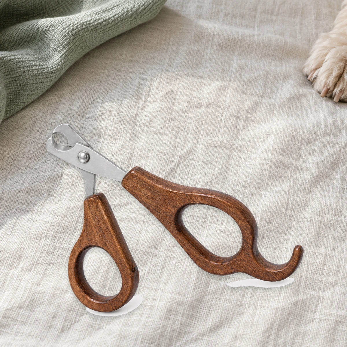 Wood-handled pet nail clippers on ivory linen
